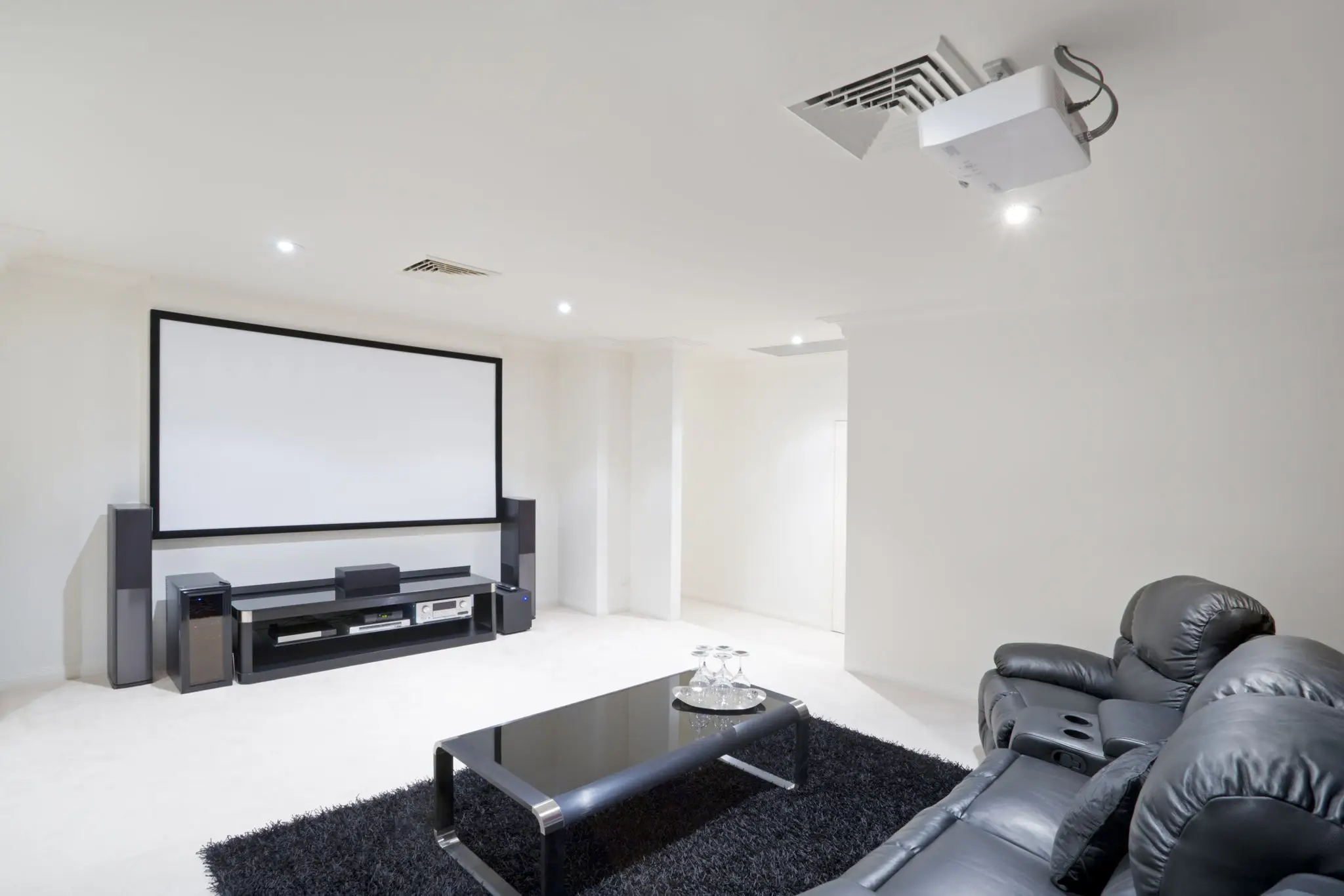 Modern home theater room with projector and comfortable seating.